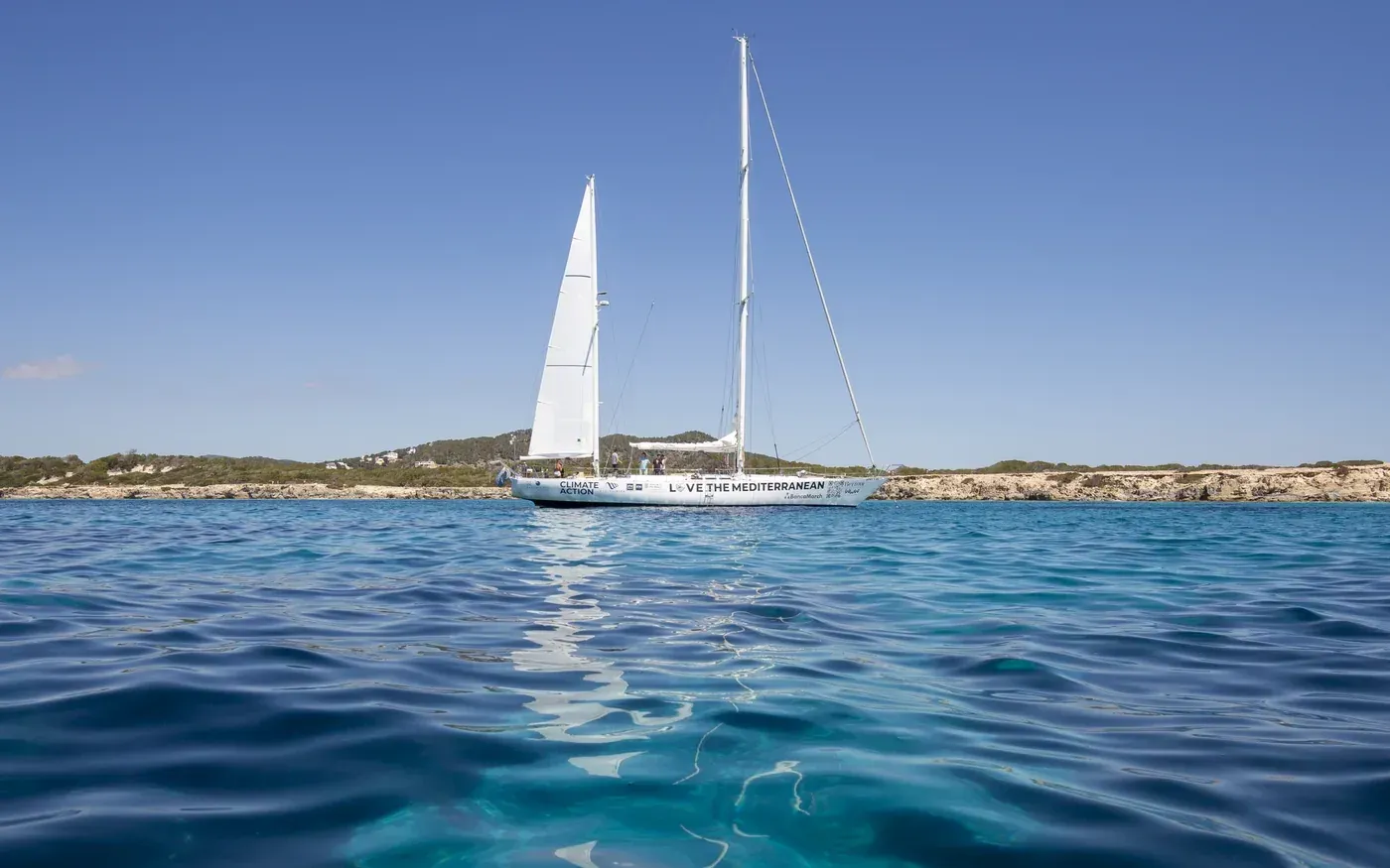 Velero de Love the Mediterranean navegando junto a la costa